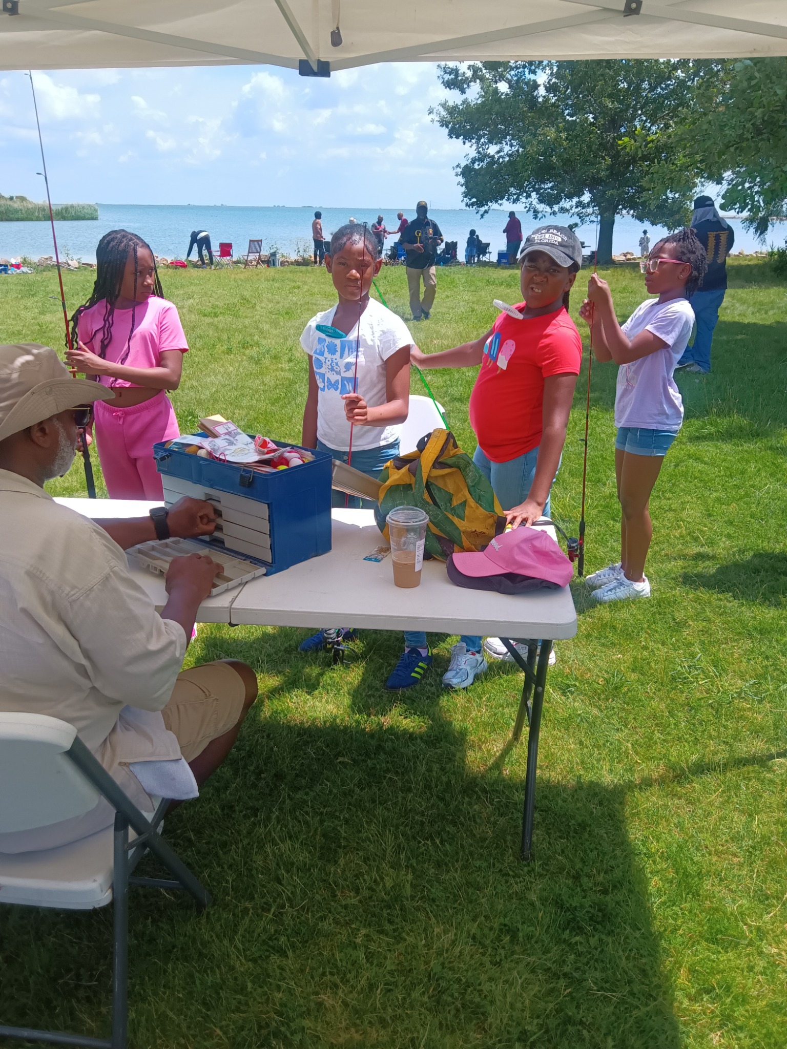 Young people learning fishing skills with a community mentor